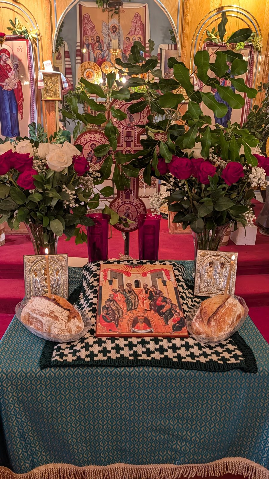 The festal tetrapod adorned with greenery, roses, and the icon of the Descent of the Holy Spirit